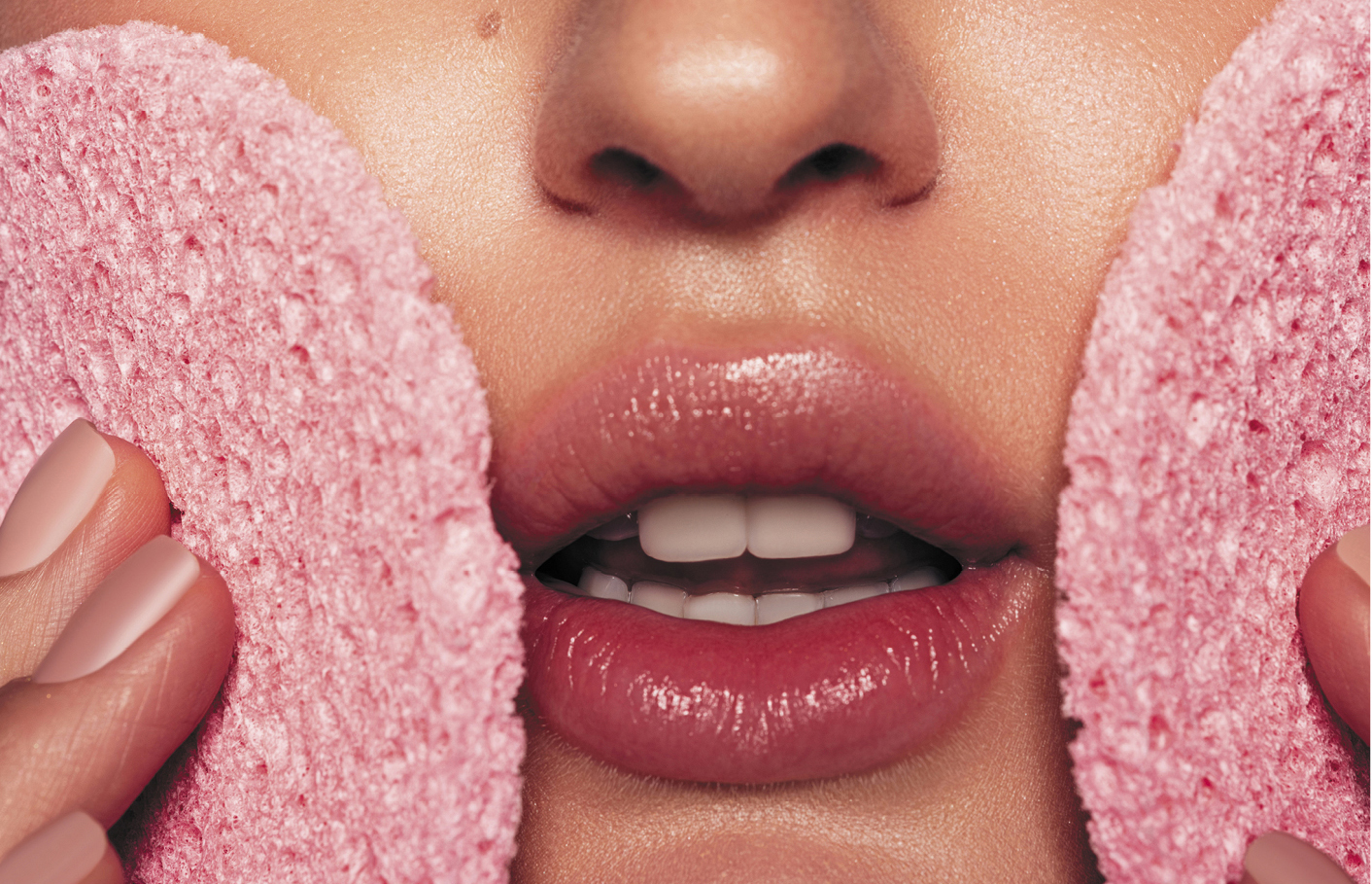 Rahn cosmetic news - woman holding two pink sponges against her cheeks, only the sponges and her lips are visible