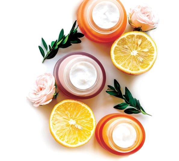 cosmetic ingredients supplier - white cream solutions in small round boxes, oranges and roses are laying around