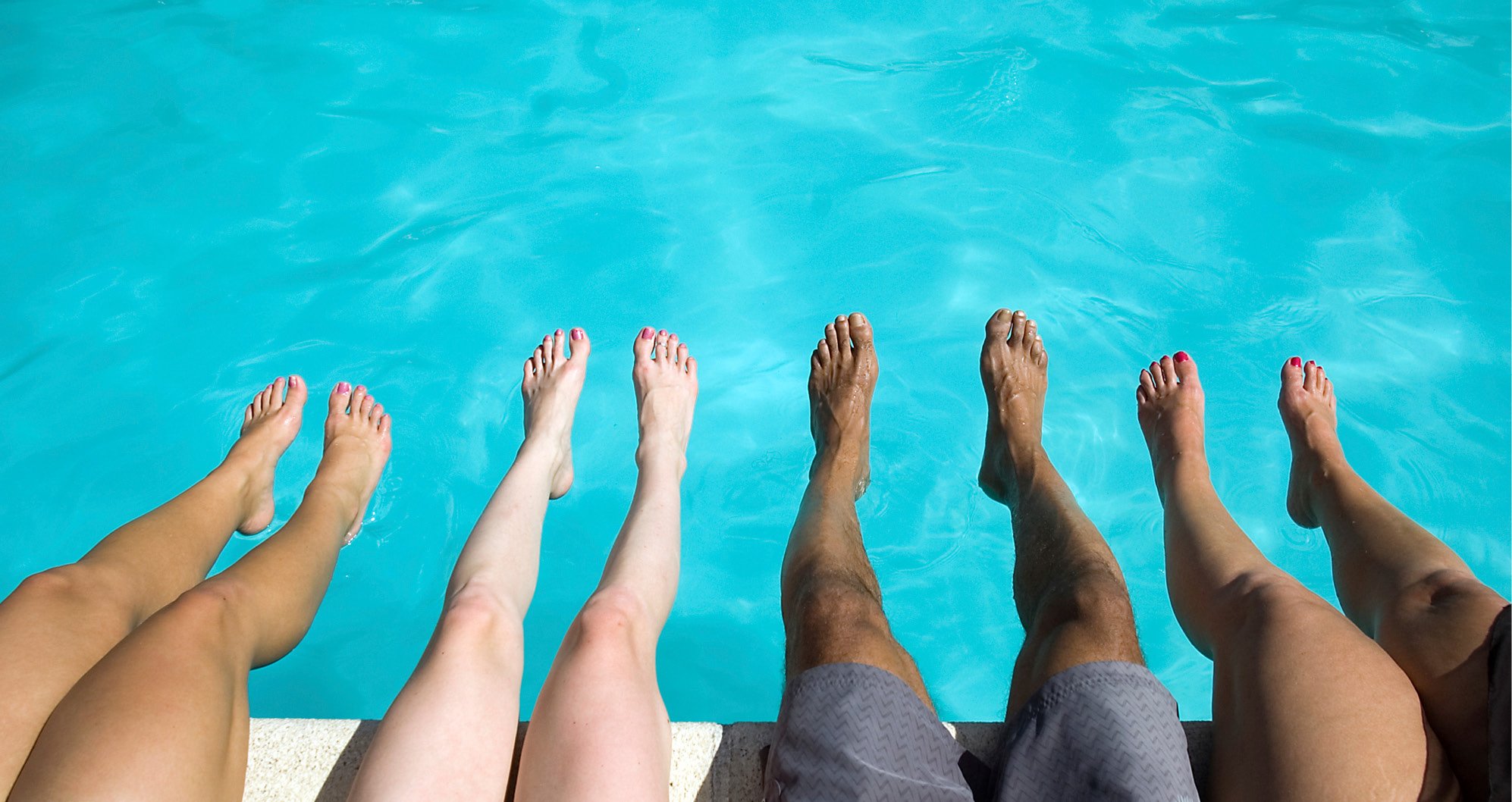 Cosmetic Services - the legs of five people, they are sitting next to a pool