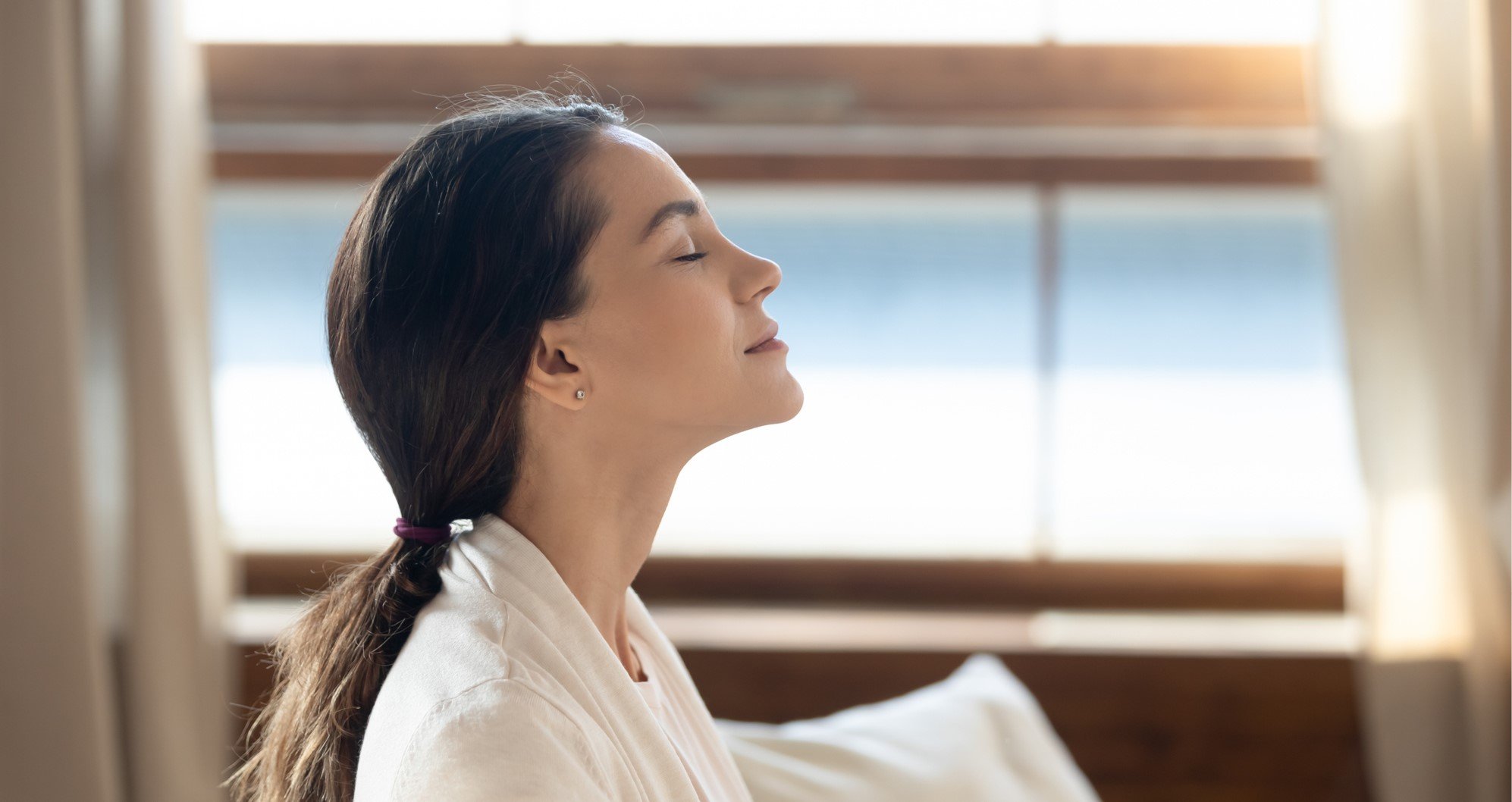 cosmetic actives trends - young woman has her hair tied together, she is wearing a white bathrobe
