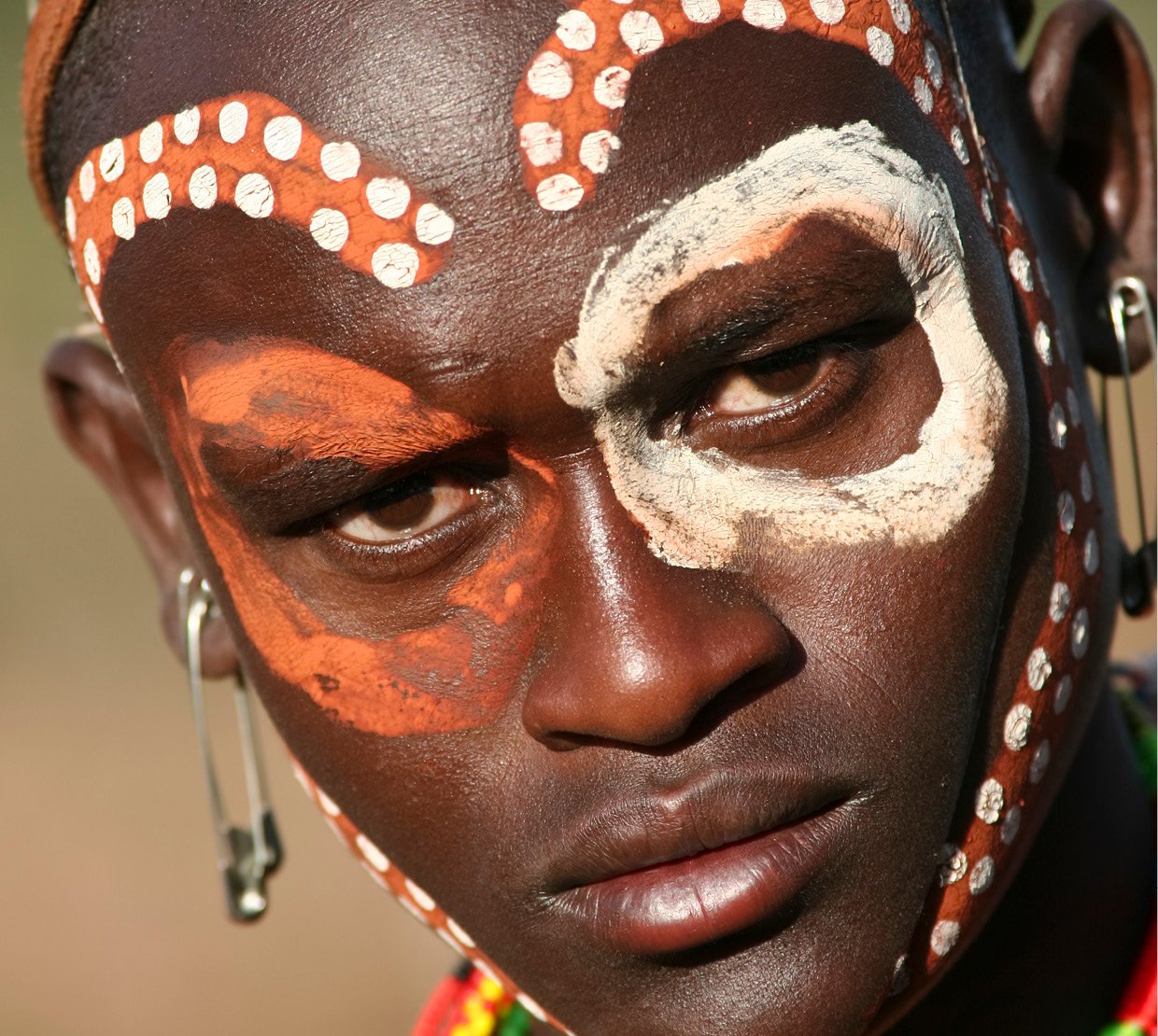 Cosmetic Services - the face of an African man having their tribe pattern painted on his face