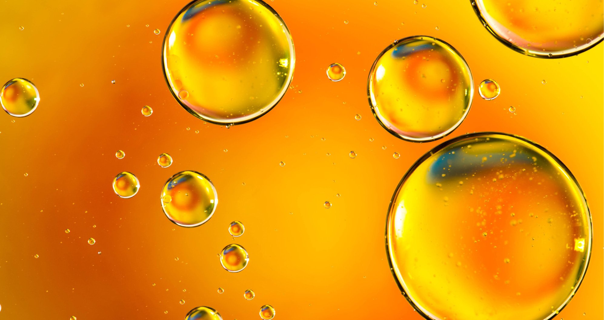 Cosmetic Services - orange oil solution with droplets that have different sizes