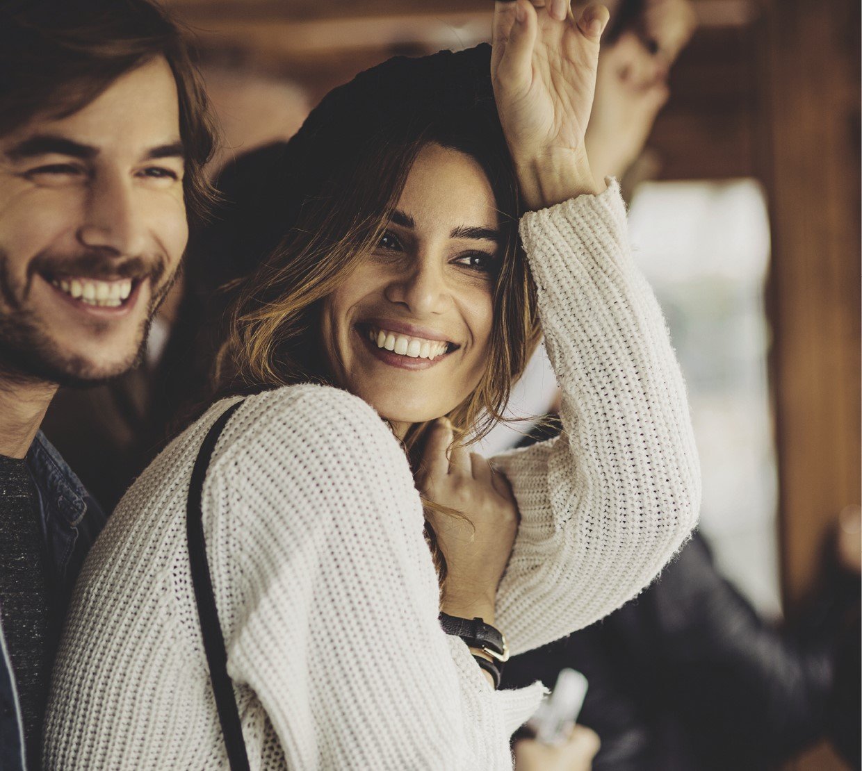 cosmetic actives trends - young woman and young man laughing together, she is wearing a white sweater